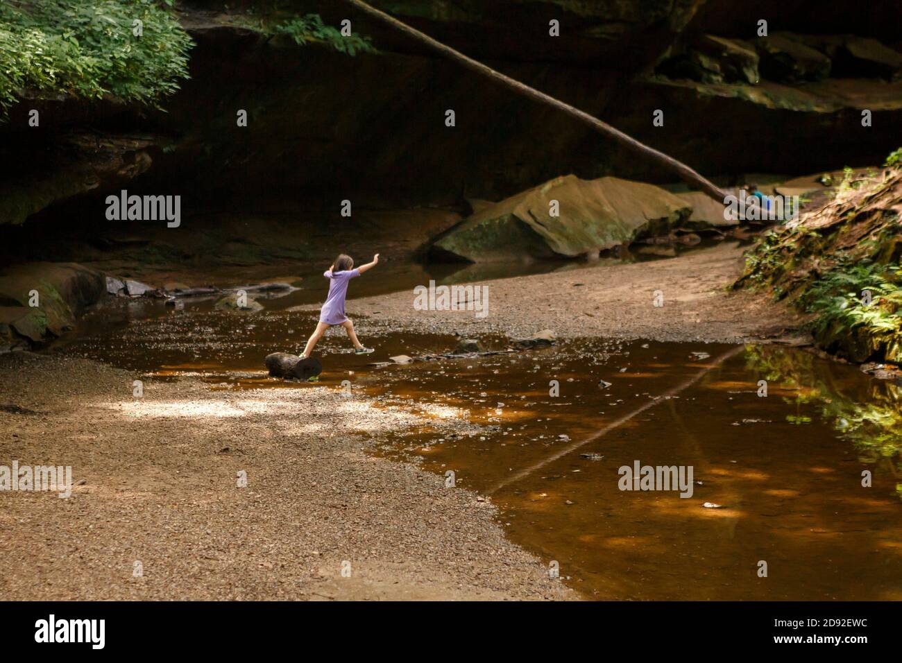 Due bambini giocano da un ruscello in una gola di arenaria in estate Foto Stock