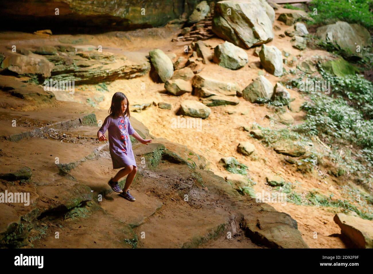 Un bambino cammina giù una scala di pietra in a. soleggiato forra di arenaria Foto Stock