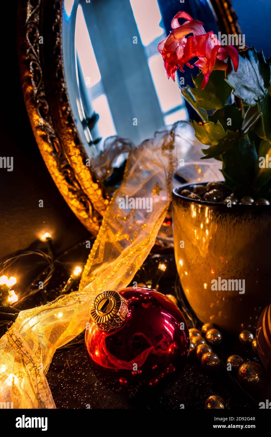 Natale ancora vita di un Natale rosso bauble, palle d'oro, un nastro di pizzo e una pianta. Foto Stock