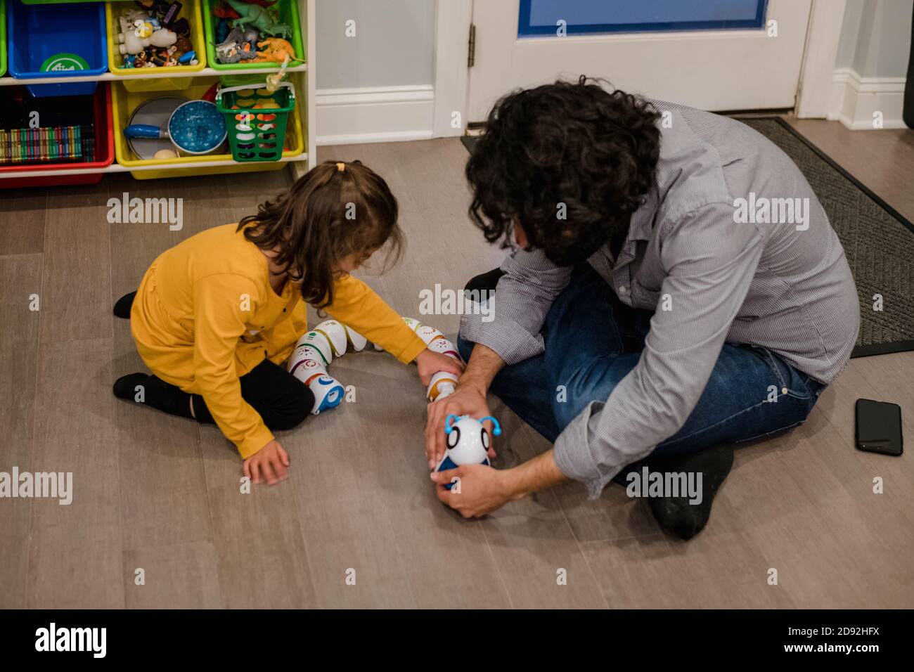 papà che aiuta la figlia con un giocattolo elettronico Foto Stock