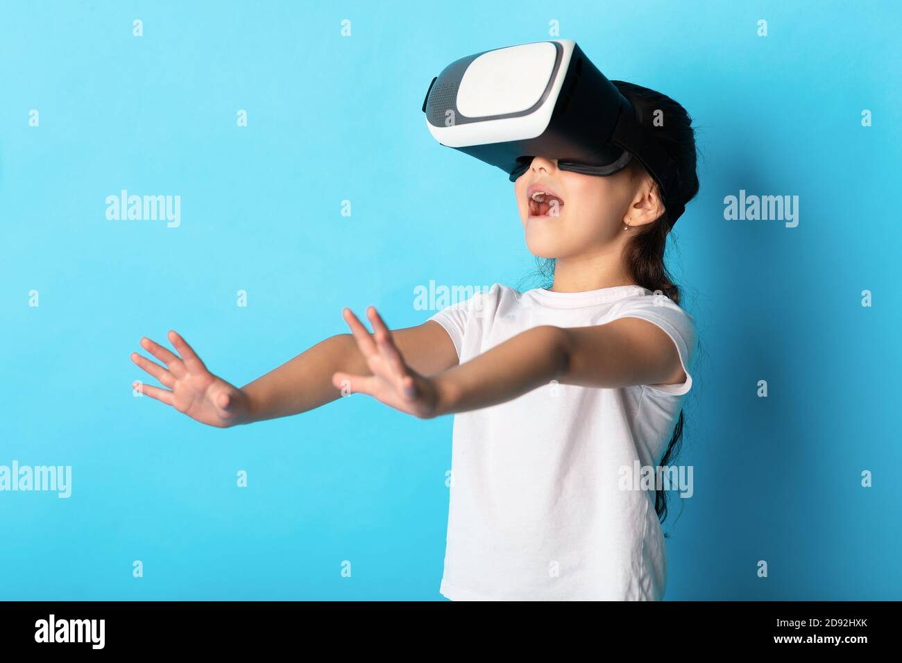 Piccola ragazza asiatica che indossa occhiali di realtà virtuale presso lo studio Foto Stock