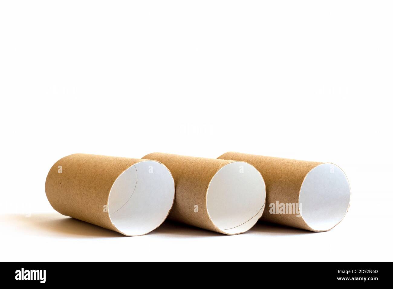 Tre tubi di carta di cartone nella fila su sfondo bianco. Primo piano dei rotoli di carta igienica vuoti, spazio per la copia Foto Stock