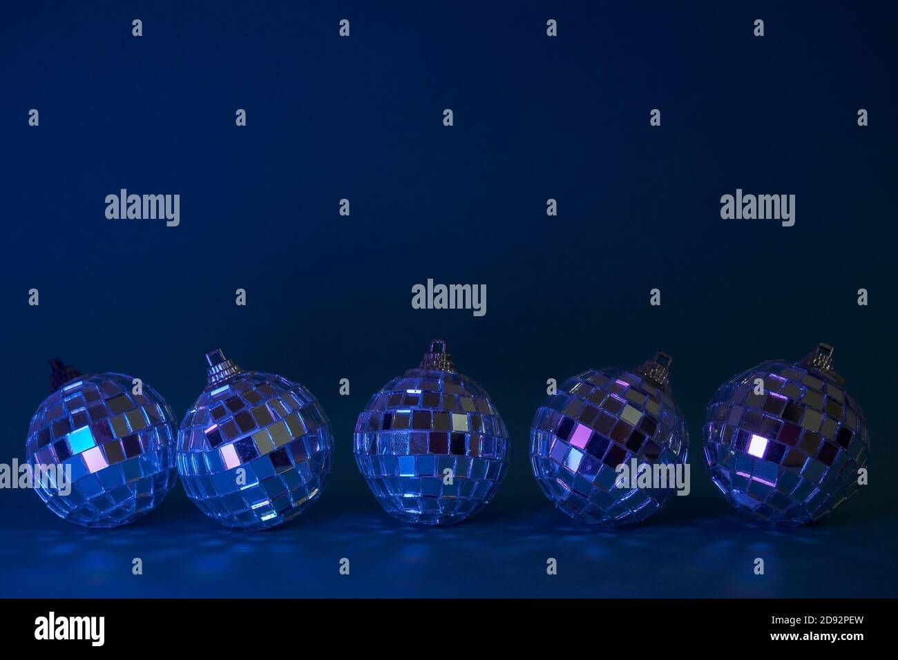 Cinque palle di natale disco su sfondo blu scuro. Concept per natale, festa e carta di nuovo anno. Spazio di copia Foto Stock