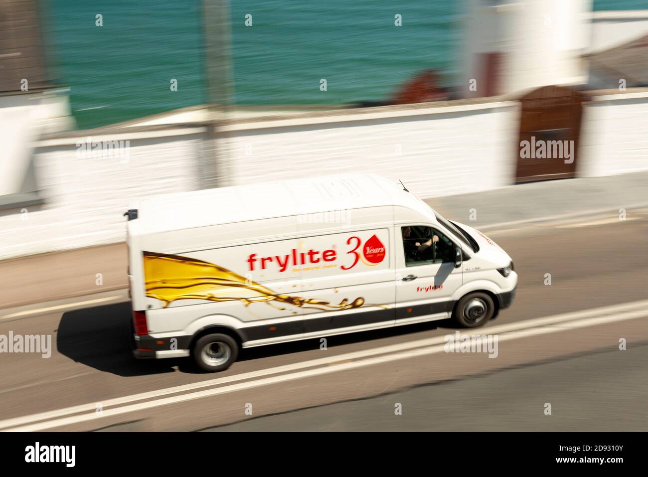 Trasporto logistico irlandese con marchio Frylite Cooking Oil, fornitore di olio da cucina, passando per il faro di Youghal a Youghal, Contea di Cork, Irlanda Foto Stock