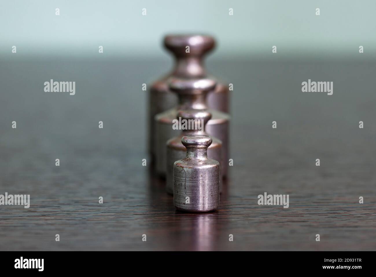 Un set di pesi di ferro graffiati vecchi per una bilancia di farmacia. Foto Stock