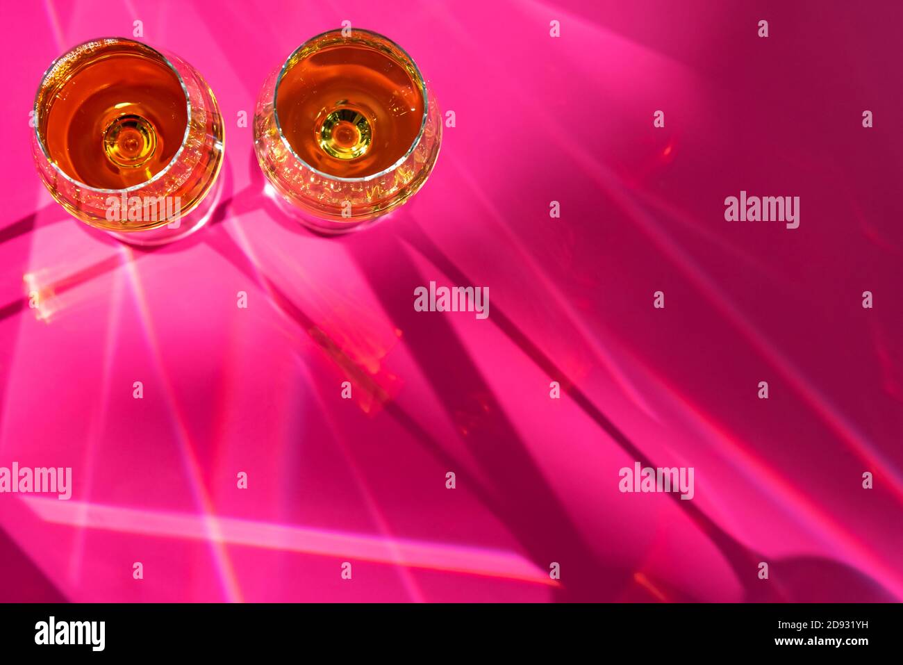Bicchieri pieni di champagne e flecks su sfondo viola Foto Stock