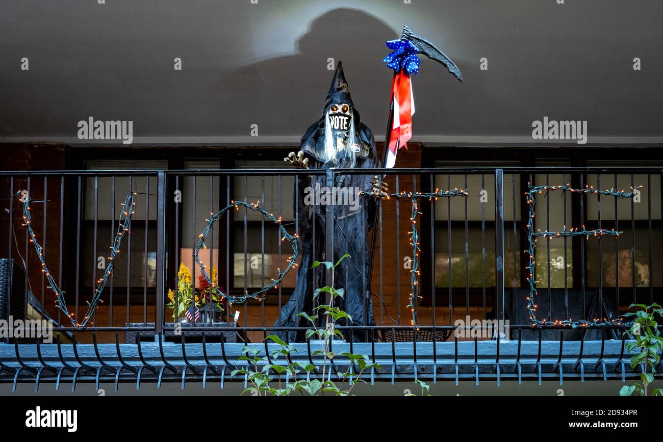 New York, Stati Uniti, 2 novembre 2020. Una figura di scheletro di Halloween indossa una maschera che incoraggia la gente a votare da un balcone nel Sid Upper East di New York City Foto Stock