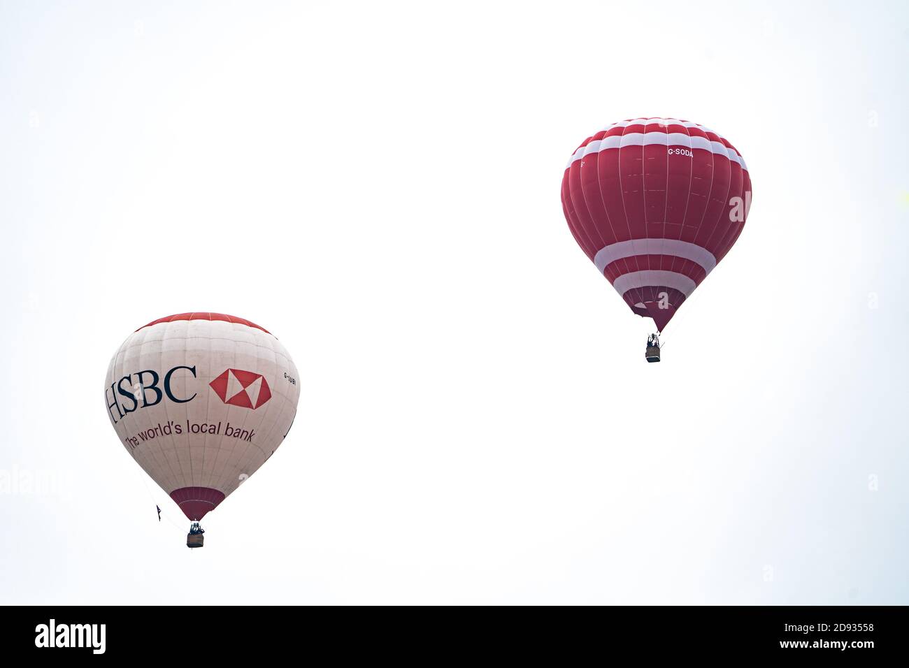 Due palloncini ad aria calda contro un cielo bianco senza caratteristiche, uno con livrea HSBC Bank, Regno Unito Foto Stock