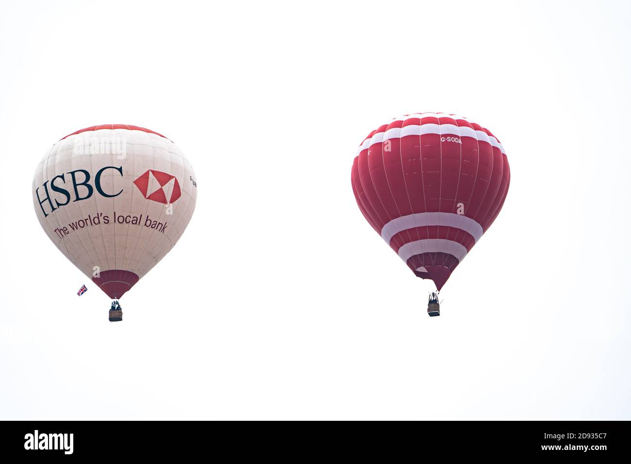 Due palloncini ad aria calda contro un cielo bianco senza caratteristiche, uno con livrea HSBC Bank, Regno Unito Foto Stock