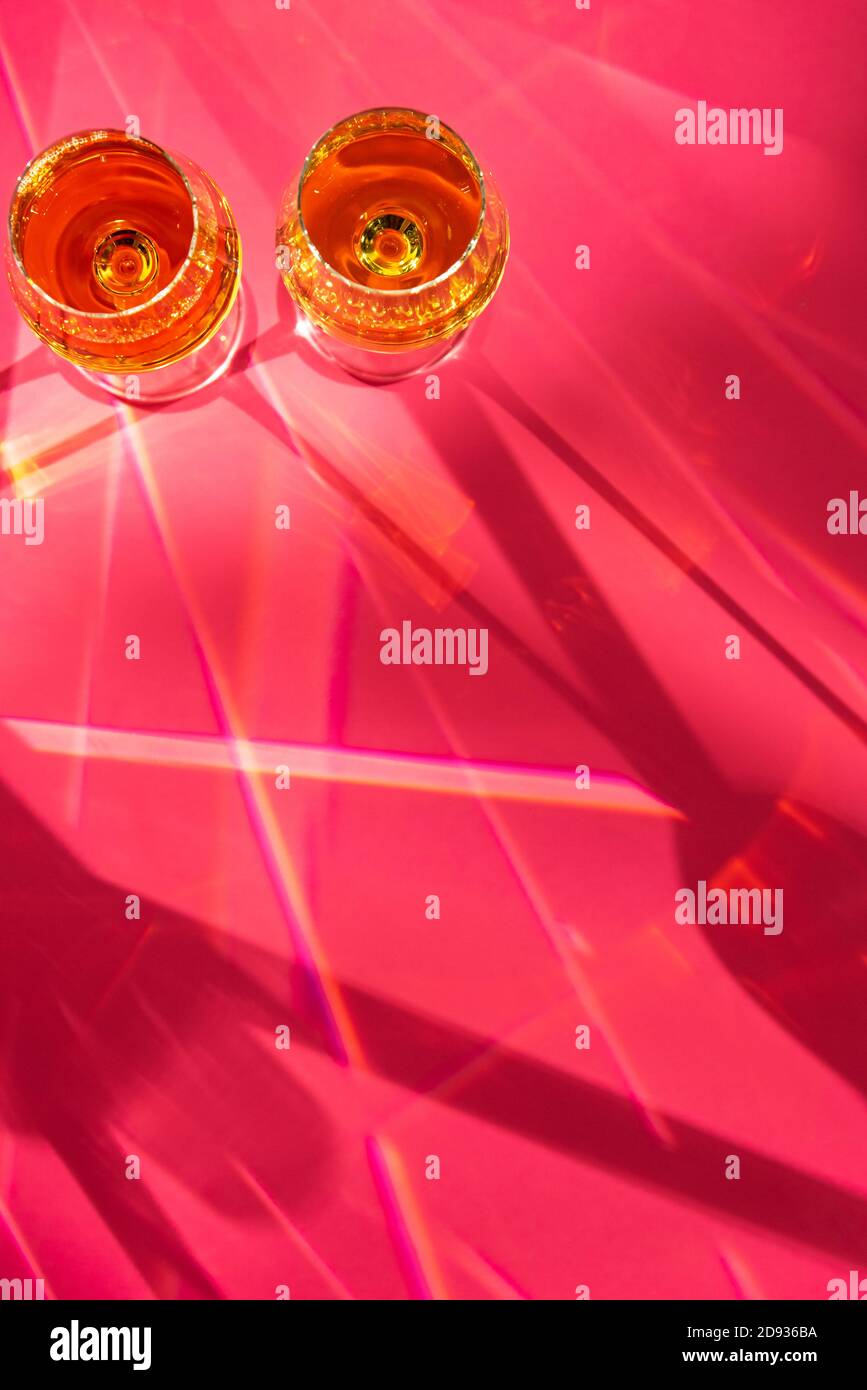 Bicchieri con champagne e macchie chiare su sfondo rosso Foto Stock