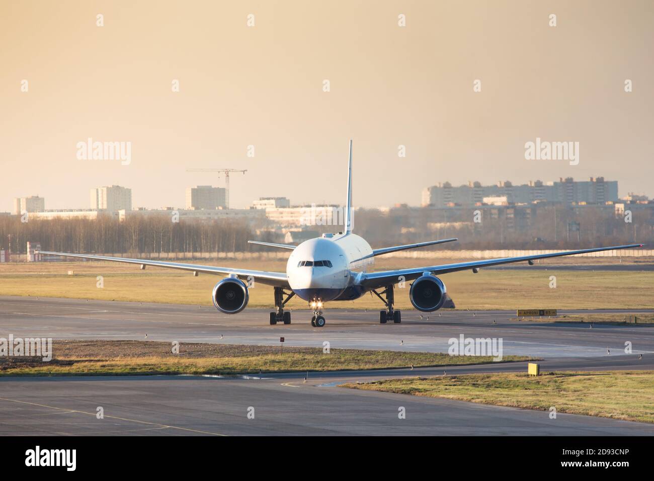 Aereo passeggeri a fusolissima che tassava sulla pista dopo l'atterraggio, durante un tramonto. Viaggio, vacanza, trasporto, concetto di aviazione Foto Stock