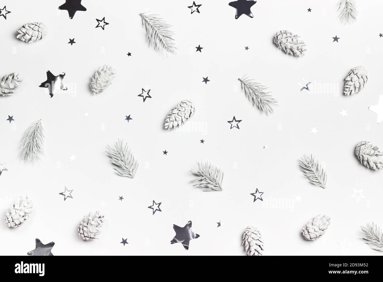 Sfondo bianco di Natale o Capodanno con pini e confetti a forma di stella argentata. Vista dall'alto. Disposizione piatta. Foto Stock