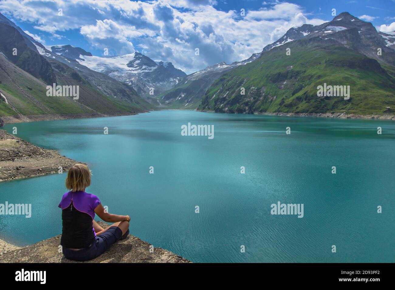 Ragazza seduta sulla roccia e godendo di una bella vista di alta lago di montagna vicino Kaprun.Quiet relax in nature.wonderful paesaggio naturale, turchese wat Foto Stock