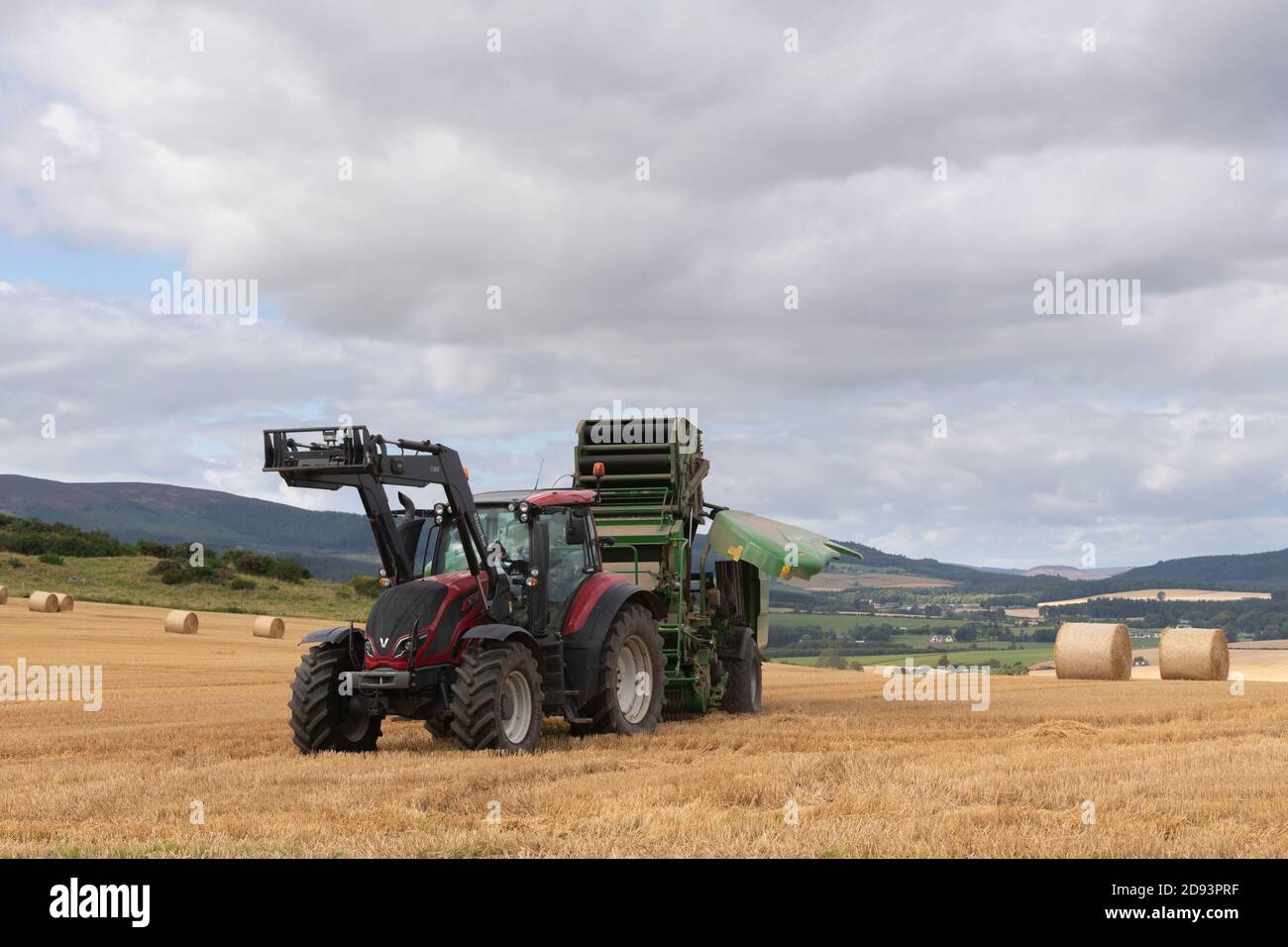 Una pressa McHale in fase di manutenzione in un campo durante la mietitura Con vista sulla campagna dell'Aberdeenshire Foto Stock