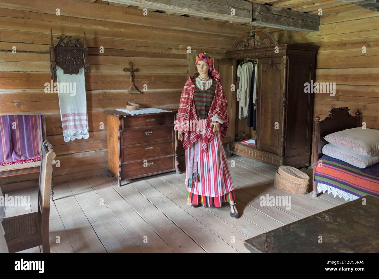Modello di donna e arredamento all'interno di una casa al museo etnografico all'aperto di Rumsiskes, Lituania Foto Stock