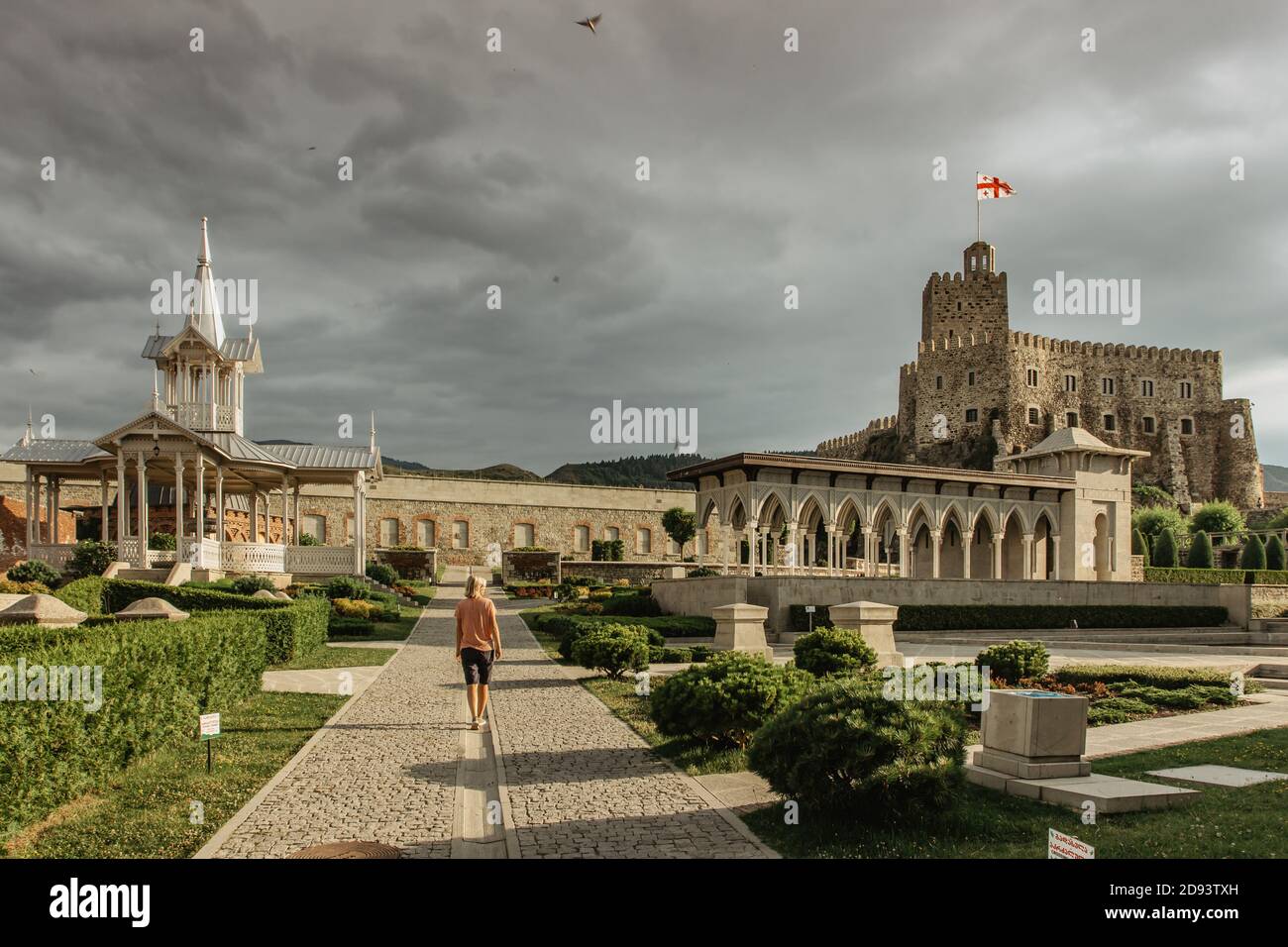 Ragazza che cammina ad Akhaltsikhe, Georgia. Rabati Castello, fortezza, situato in una piccola città nel sud della Georgia.There è Akhmediye Moschea, la moschea minar Foto Stock