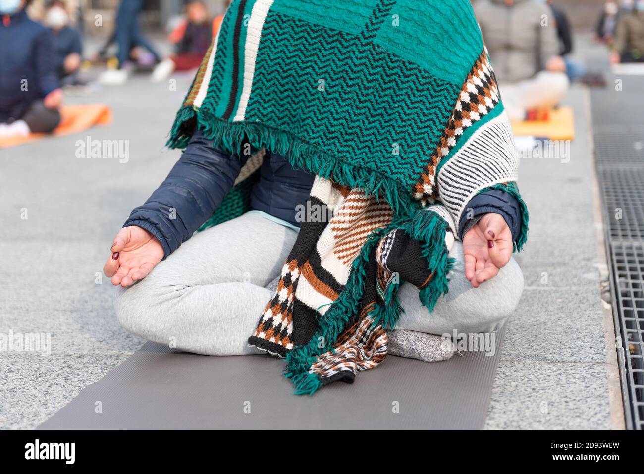 Insegnanti di yoga che protestano contro il blocco e le restrizioni del Covid-19 in una piazza a Brescia, Italia. Colpo delle mani che poggiano sulle ginocchia di Th Foto Stock