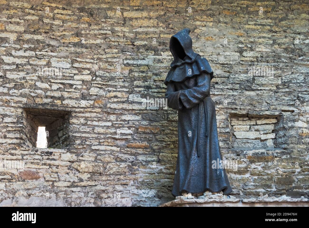 Statua monaca senza volto vicino alle mura medievali della città nella città vecchia, Tallinn, Estonia Foto Stock