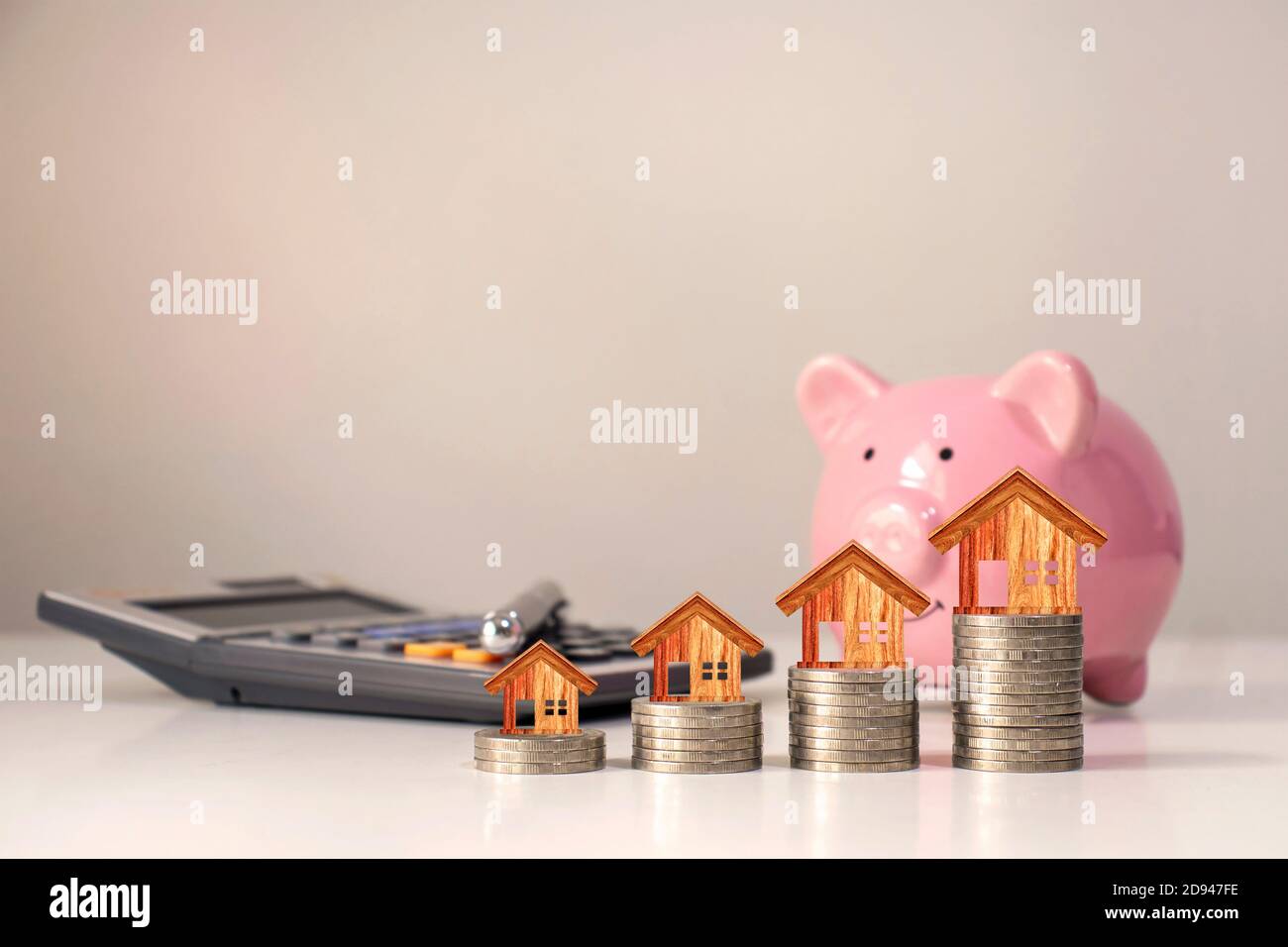 Modello di casa che è sul tavolo pila di monete per la finanza e il concetto bancario. Foto Stock