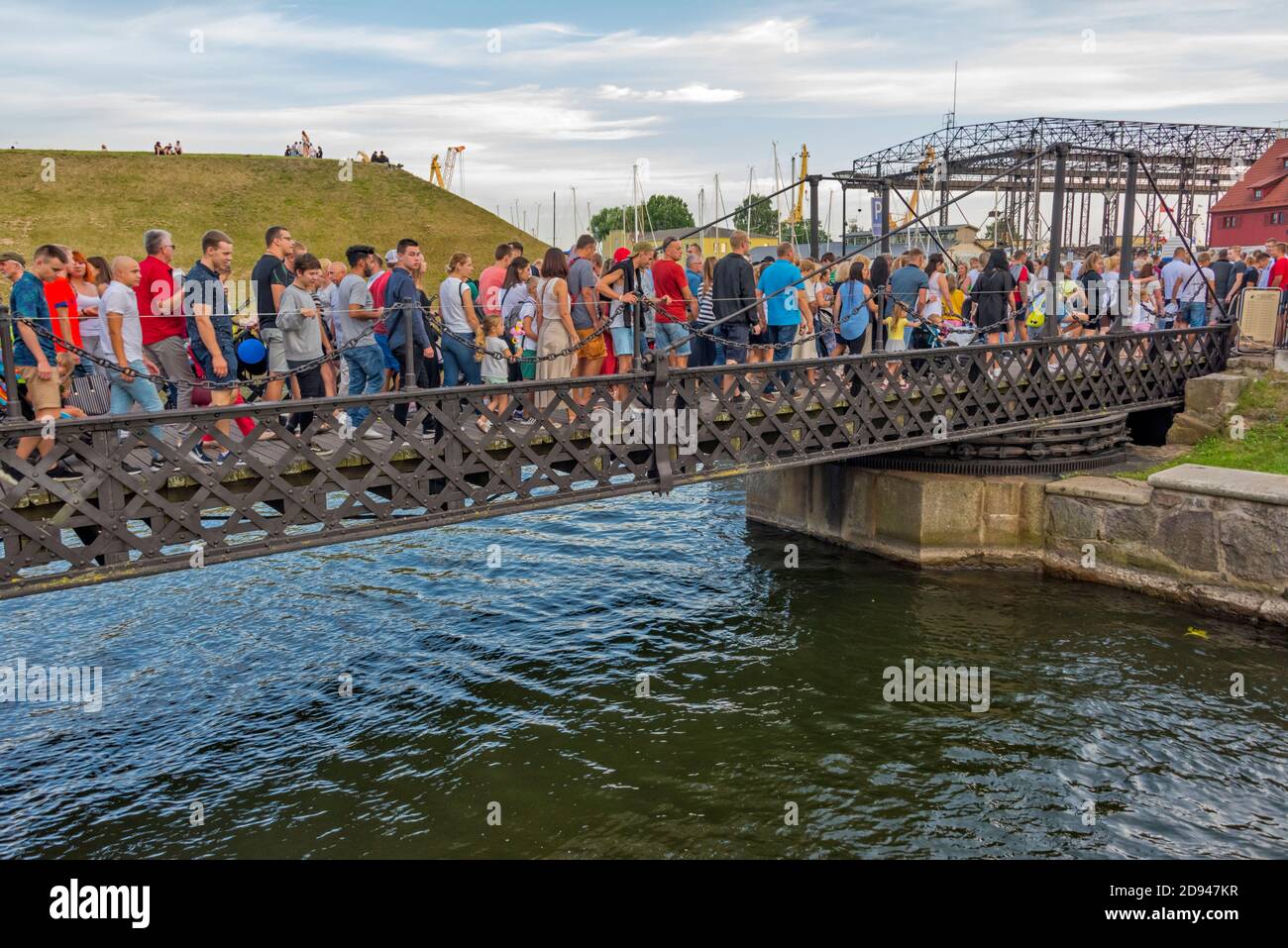 Persone che attraversano il Ponte delle catene (l'unico ponte sospeso della Lituania ruotato da due persone) durante il Klaipeda Sea Festival, Klaipeda, Lituania Foto Stock
