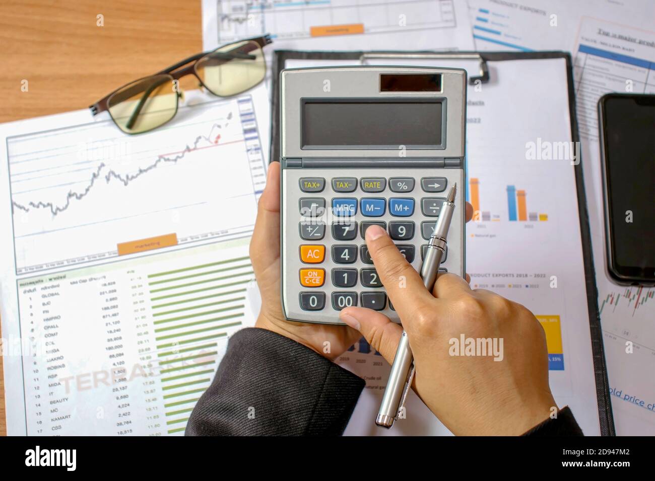 Gli imprenditori utilizzano un calcolatore per calcolare le spese in base al concetto di crescita finanziaria e di risparmio per gli investimenti. Foto Stock