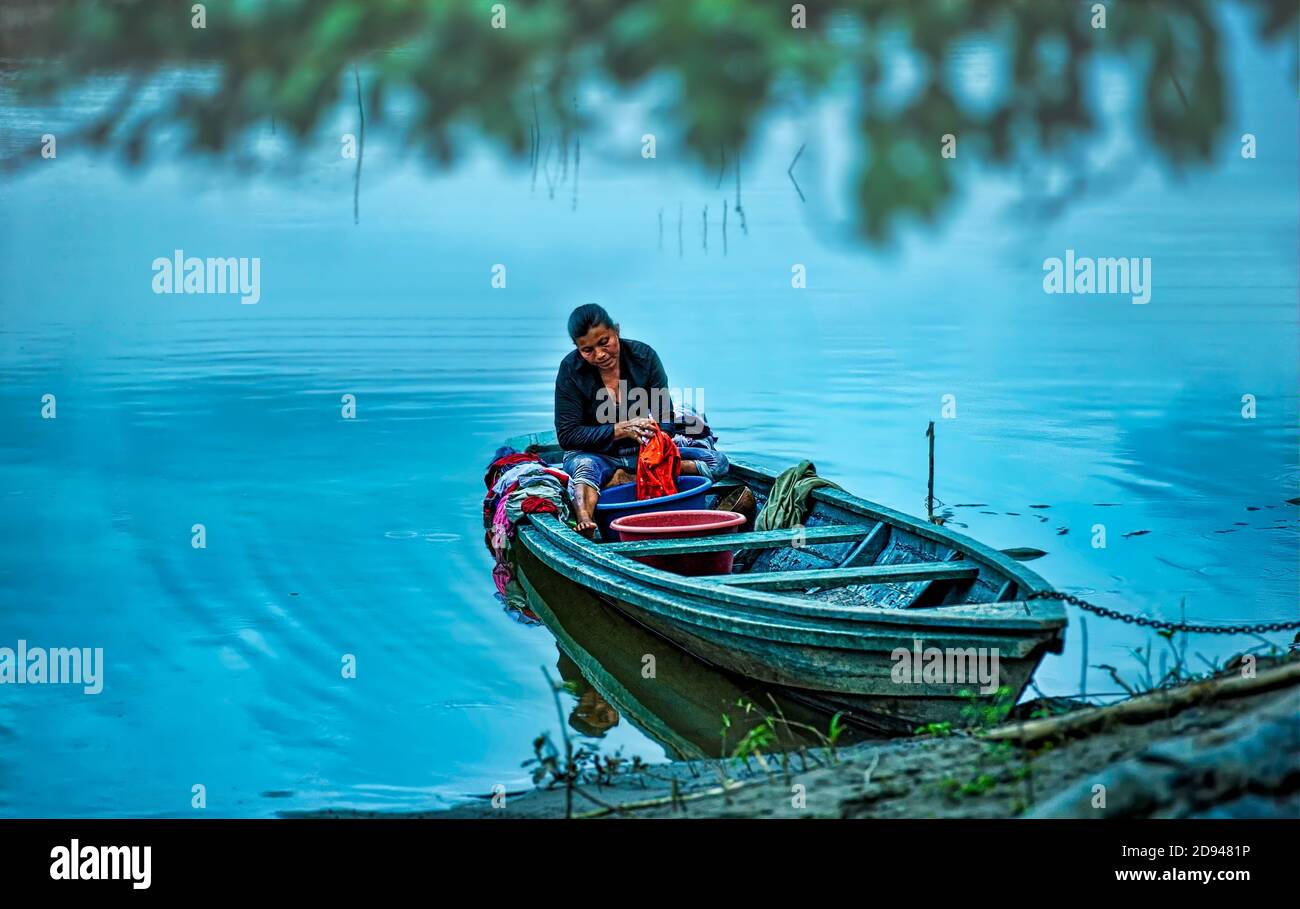 Locale Yagua indiano tribeswoman che fa il lavaggio quotidiano mentre ormeggiato Nella sua barca a Monkey Island sul fiume Amazzonia Vicino alla città di Iquitos Foto Stock