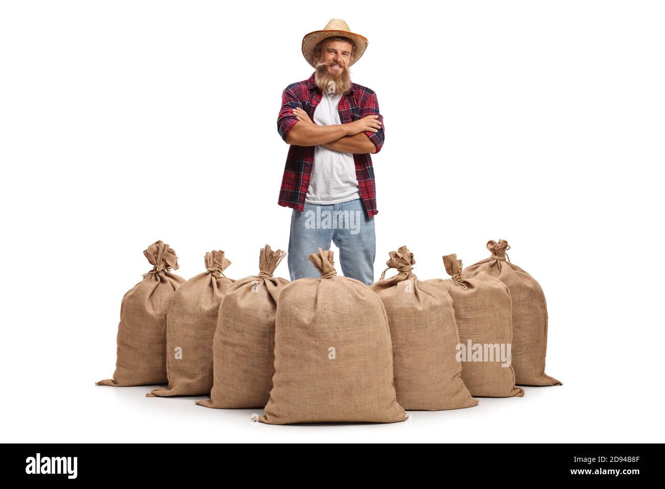 Coltivatore bearded in piedi dietro sacchi di scappatele con patate isolate sopra sfondo bianco Foto Stock