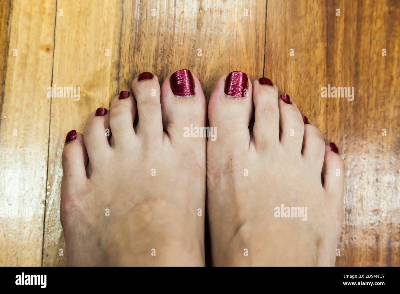 donne piedi dopo pedicure con sfondo rosso unghie Foto Stock