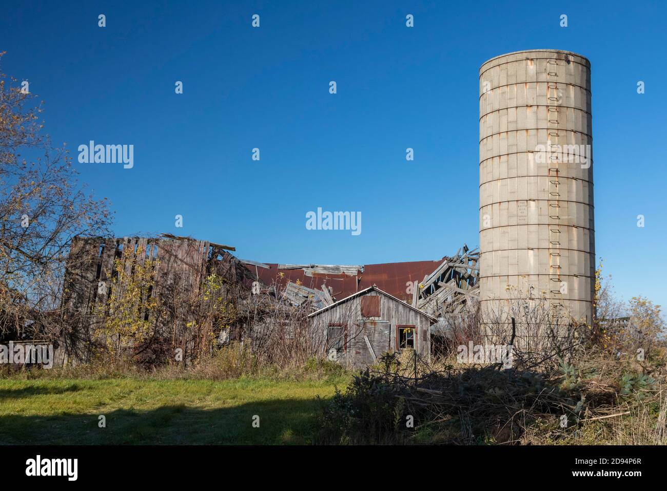 Marlette, Michigan - le rovine di un fienile e di un vecchio silo di cemento in una fattoria del Michigan. Foto Stock