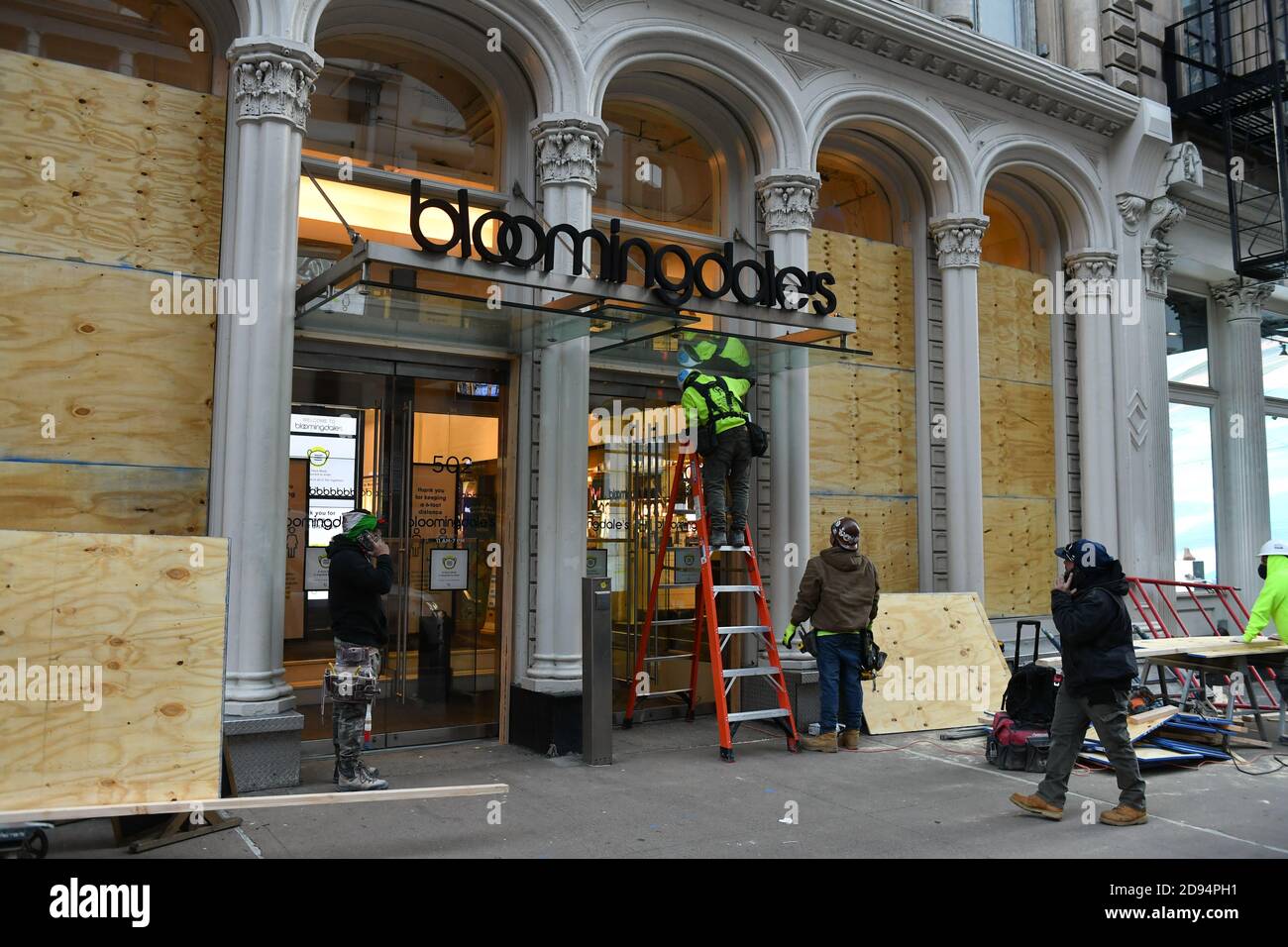 I lavoratori coprono le finestre del SoHo Bloomingdale's il 1° novembre 2020 a New York. Le mosse vengono quando i rivenditori cercano di proteggersi contro il loo Foto Stock