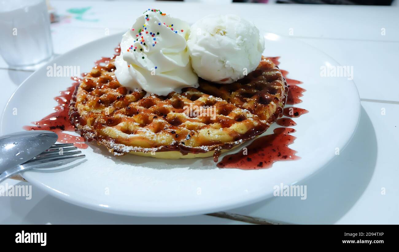 Frittelle a nido d'ape con gelato come una farcitura sulla parte superiore è uno spuntino di dessert dopo aver mangiato dal pasto principale. Foto Stock