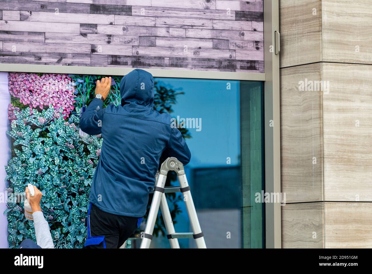 Lavoratori che installano pellicole per finestre all'aperto. Installazione di una lamina per cristalli. Foto Stock