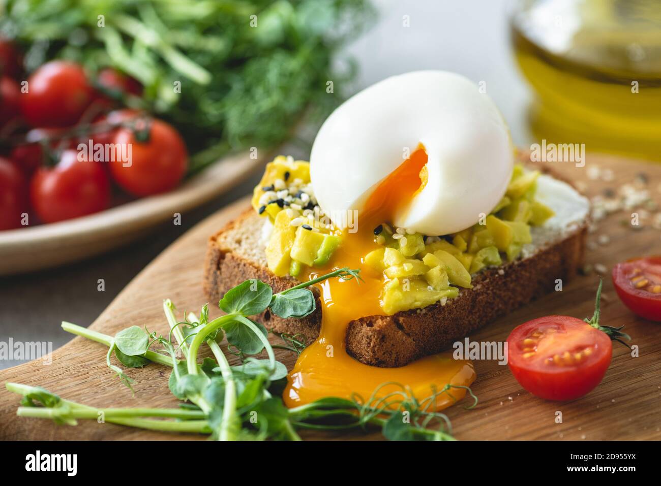 Tostare con avocado e uovo guarnito con semi di sesamo. Colazione sana, pranzo o spuntino Foto Stock