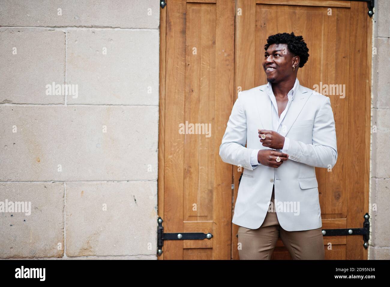 Pensieroso giovane bel Signore afroamericano in formalwear. Uomo modello nero elegante con giacca bianca Foto stock Alamy