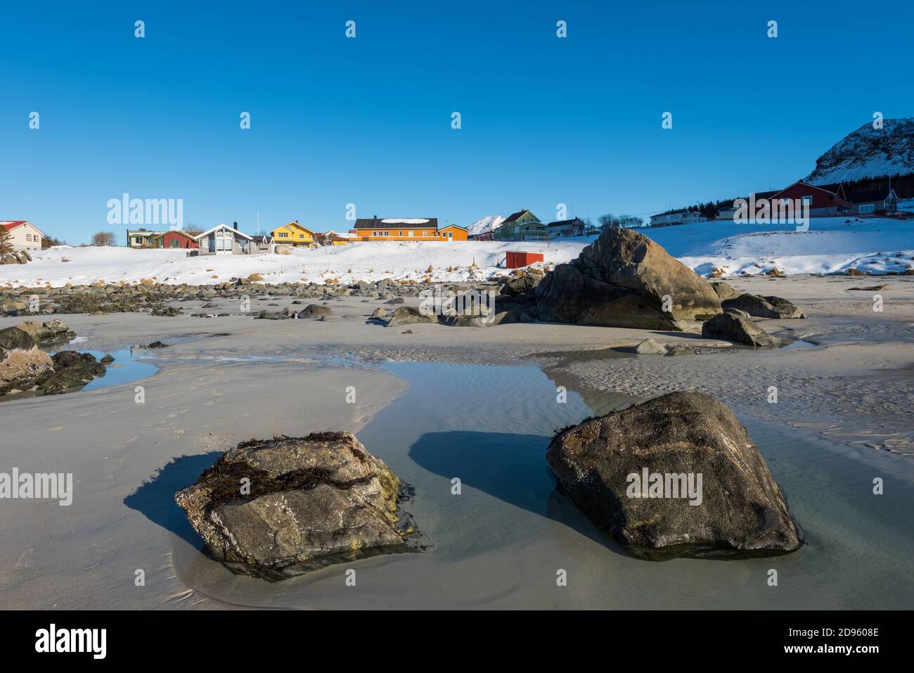 La famosa spiaggia di sabbia dall'aspetto tropicale vicino a Ramberg sulla Lofoten isole in Norvegia in chiaro giorno d'inverno con neve-rivestito montagne e cielo blu Foto Stock