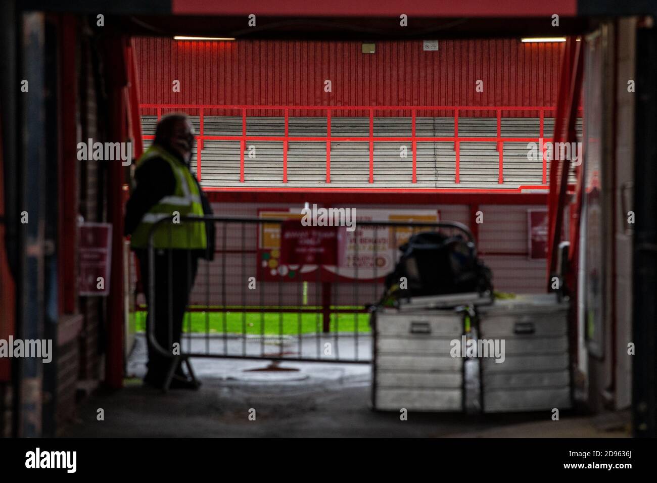 Steward si trova accanto all'ingresso dei giocatori allo stadio di calcio vuoto che si trova davanti Di gioco che si gioca a porte chiuse durante la pandemia di Covid-19 In Inghilterra Regno Unito Foto Stock