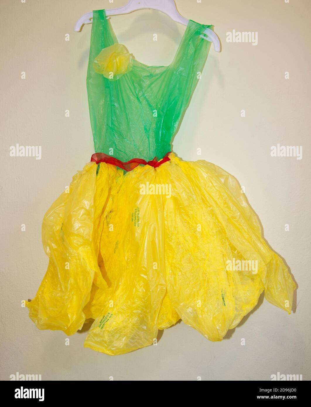 Abito dai colori vivaci realizzato con materiali riciclabili dai bambini durante una lezione sul riciclaggio, riutilizzando gli oggetti di tutti i giorni. Foto Stock