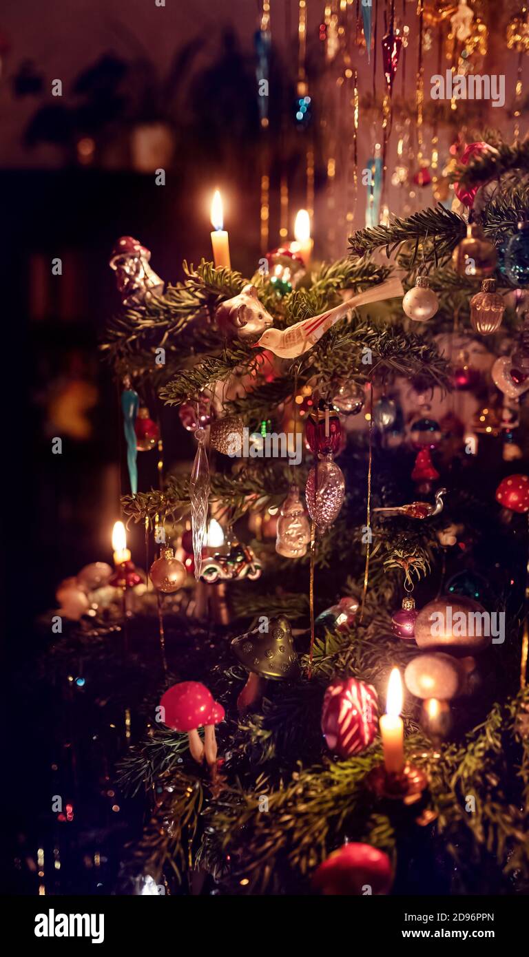 Un dettaglio di un classico albero di Natale tedesco con candele reali e un sacco  di tinsel. Illuminato da luce a candela con molti ornamenti diversi Foto  stock - Alamy