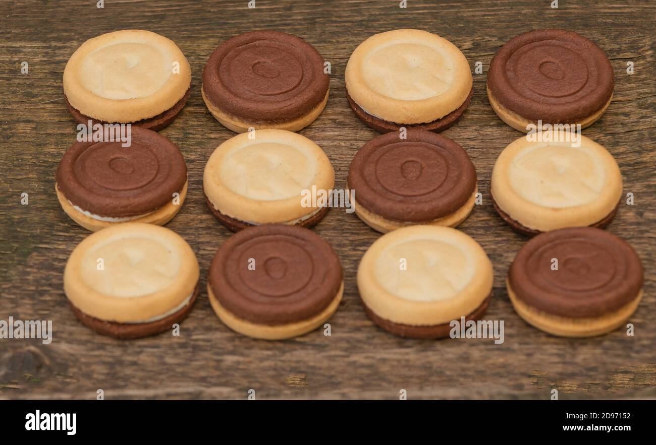 Tre sapori in un unico biscotto, due lati e una deliziosa crema al centro. Sfondo di legno Foto Stock