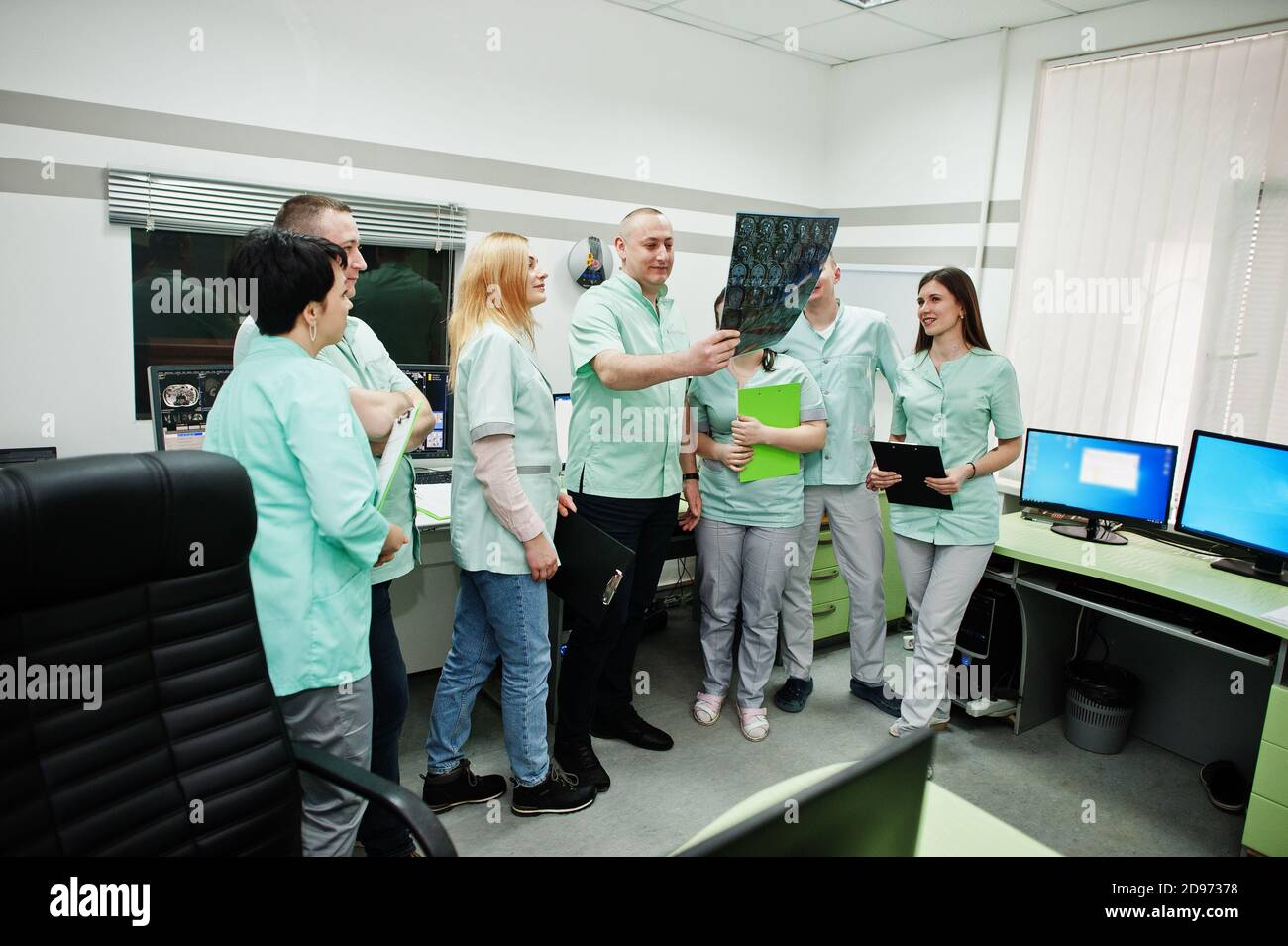 Tema medico. Sala di osservazione con un computer tomografo. Il gruppo di medici che si riuniscono nell'ufficio di rm e che guardano i raggi X al centro diagnostico in Foto Stock