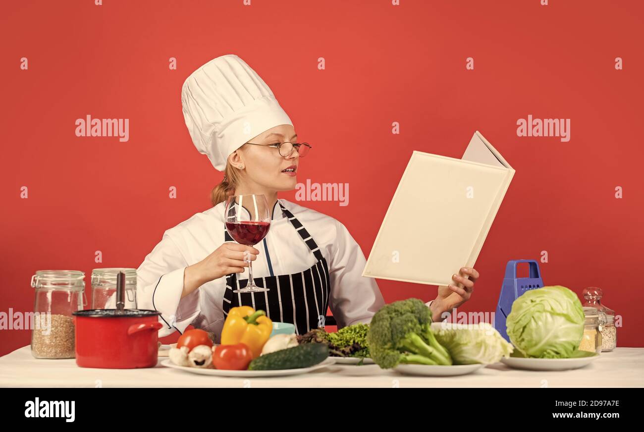 pratica di più. chef professionista leggere la ricetta per cucinare. chef femminile preparare il piatto. cucinare nella sua cucina. Apri il ricettario per una cucina sana. Mantiene un segreto sugli ingredienti. Donna utilizza Cookbook. Foto Stock