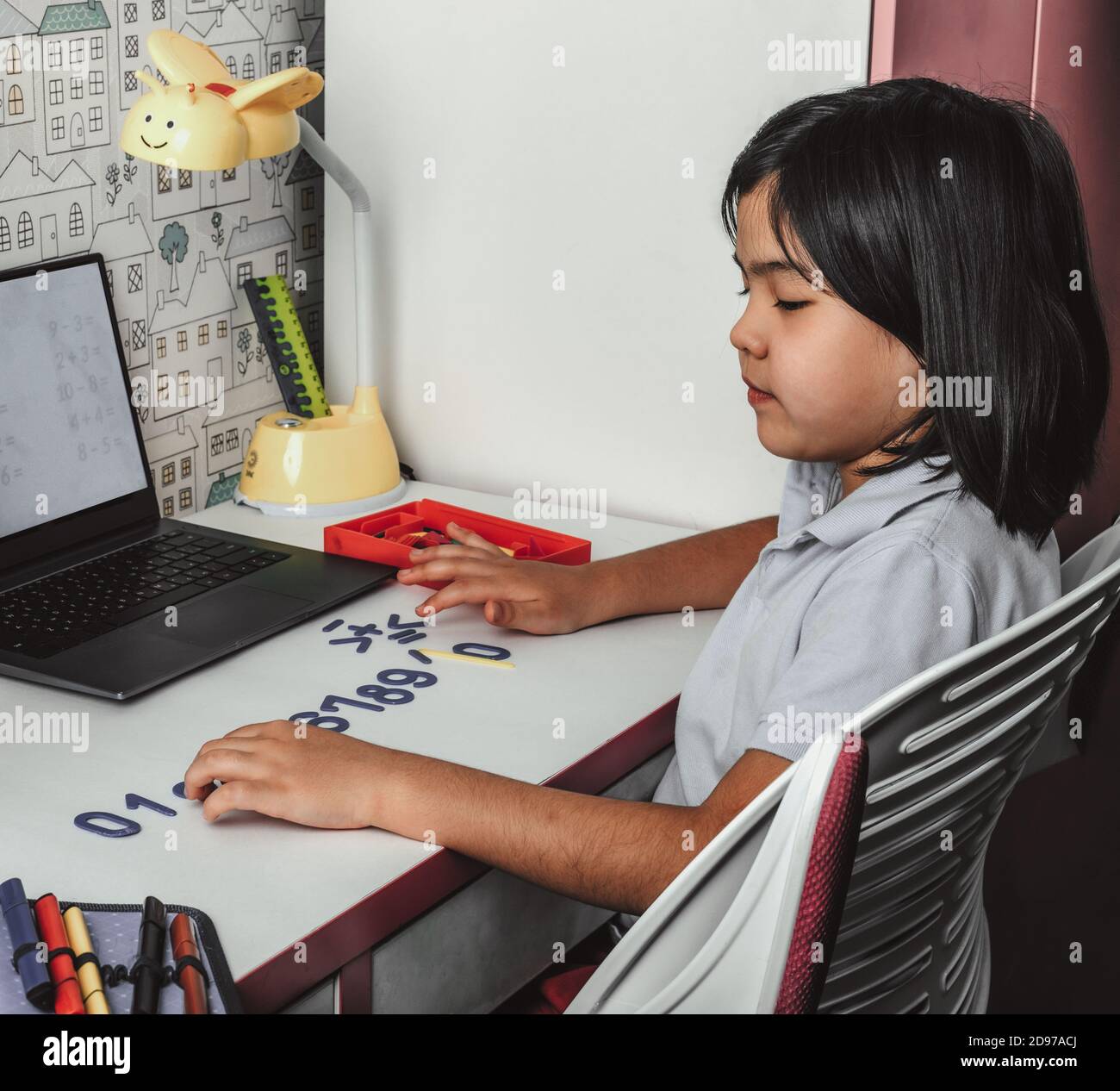 Studentessa asiatica che studia matematica a casa durante la sua lezione online, videochiama zoom con il computer portatile a casa. Nuovo normal.Covid-19 coronavirus. Sociale Foto Stock