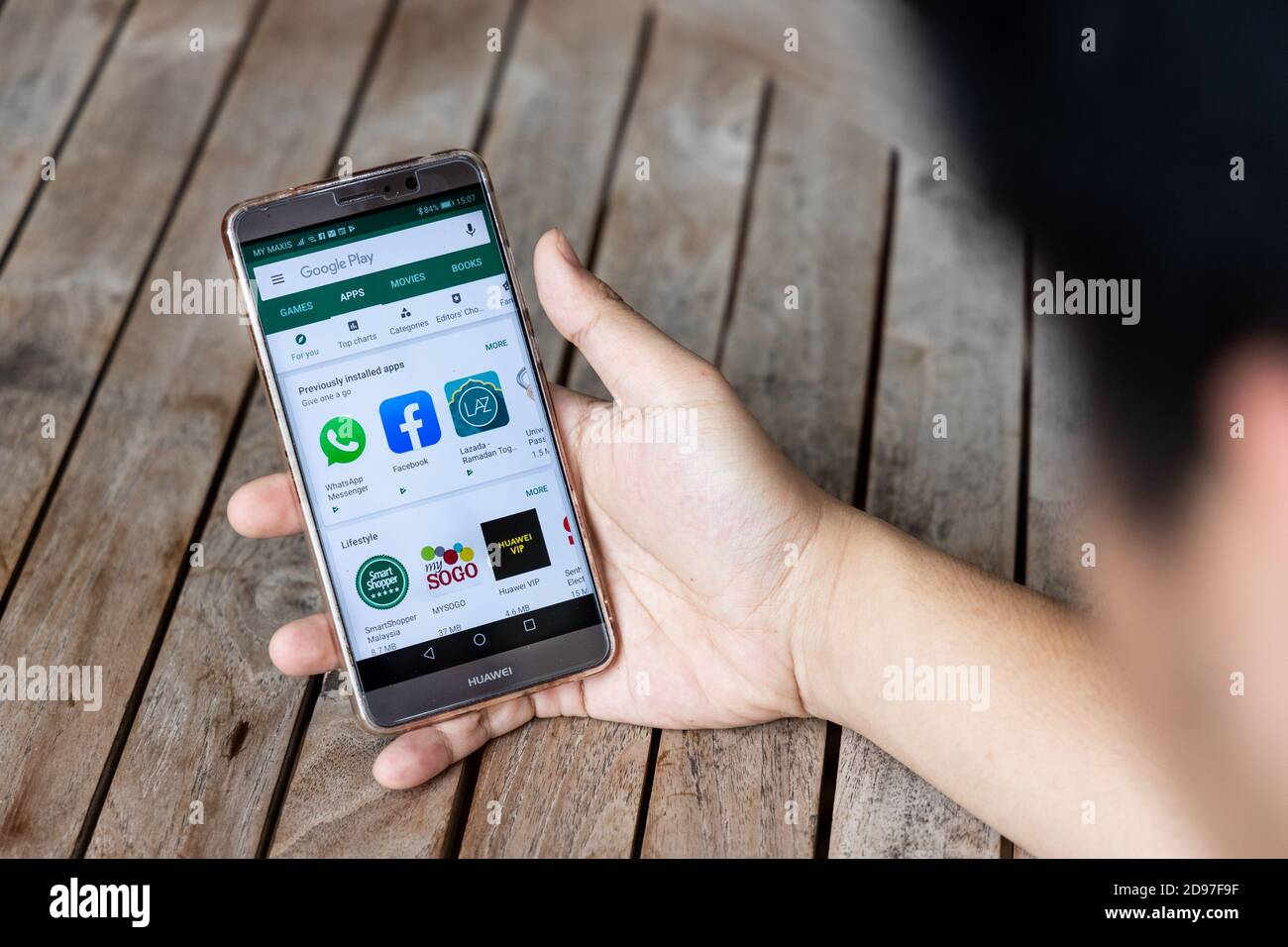 Persona che tiene il telefono Huawei Mate con Google Play Store. Le aziende americane hanno cominciato a limitare le vendite a Huawei cinese di telecomunicazioni Foto Stock