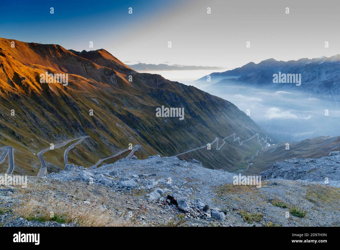 Passo dello Stelvio con montagne innevate e una strada tortuosa nella valle, Trentino-Alto Adige, Italia Foto Stock