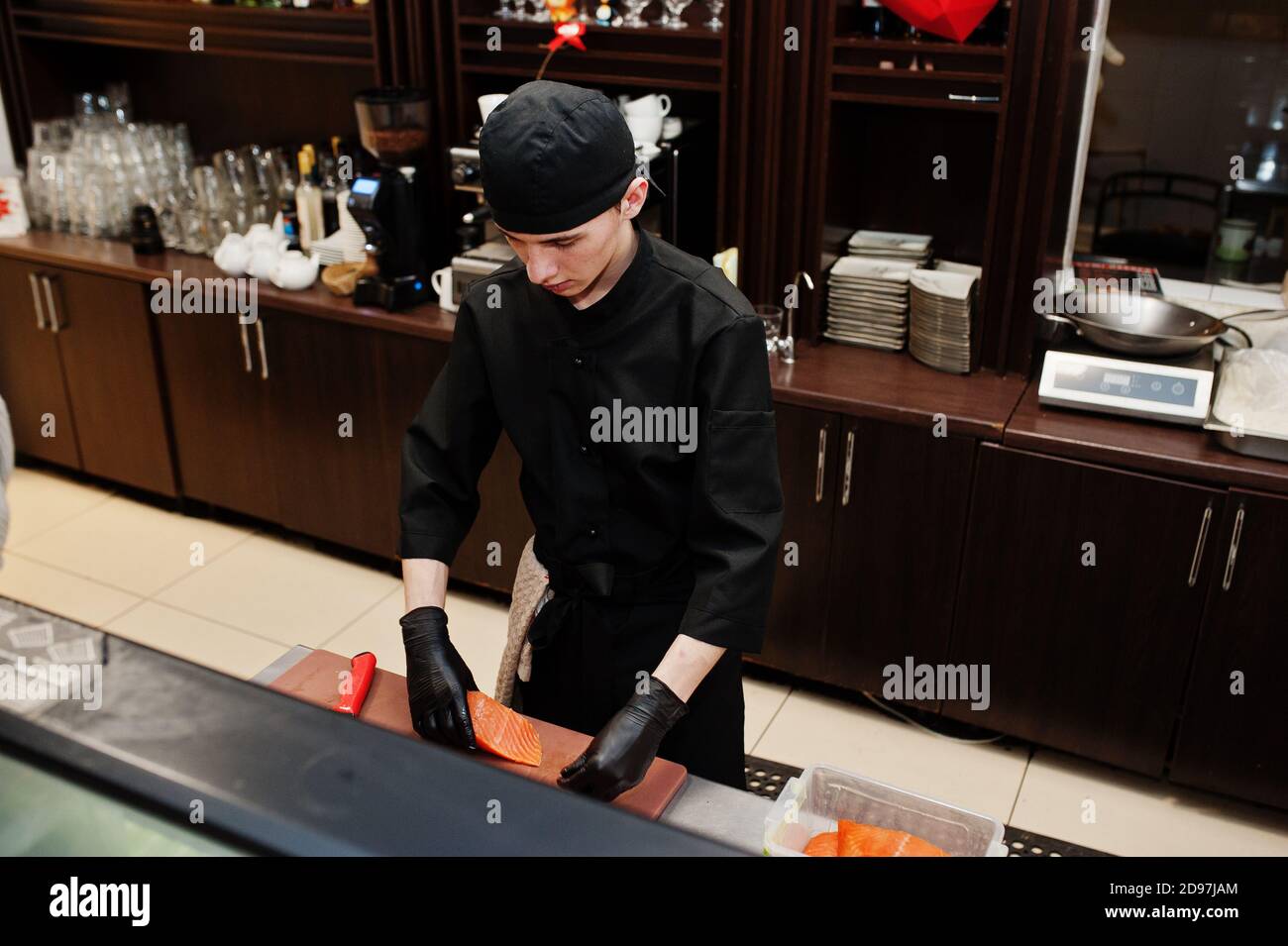 Chef professionista indossa sushi e panini neri in una cucina ristorante di cibo tradizionale giapponese. Foto Stock