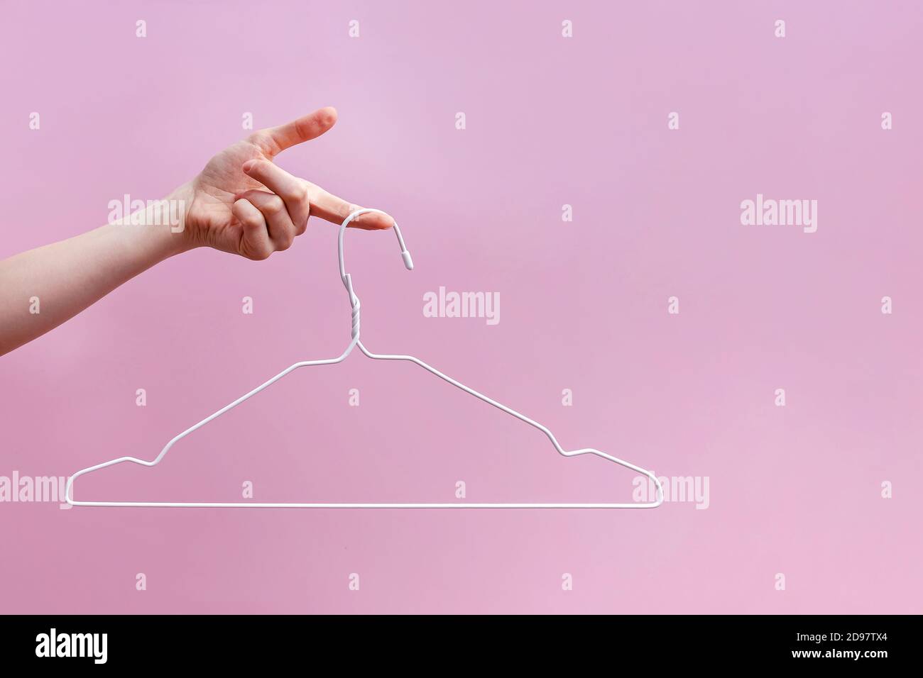 Appendiabiti vuoto per mano femminile isolato su sfondo rosa Foto Stock