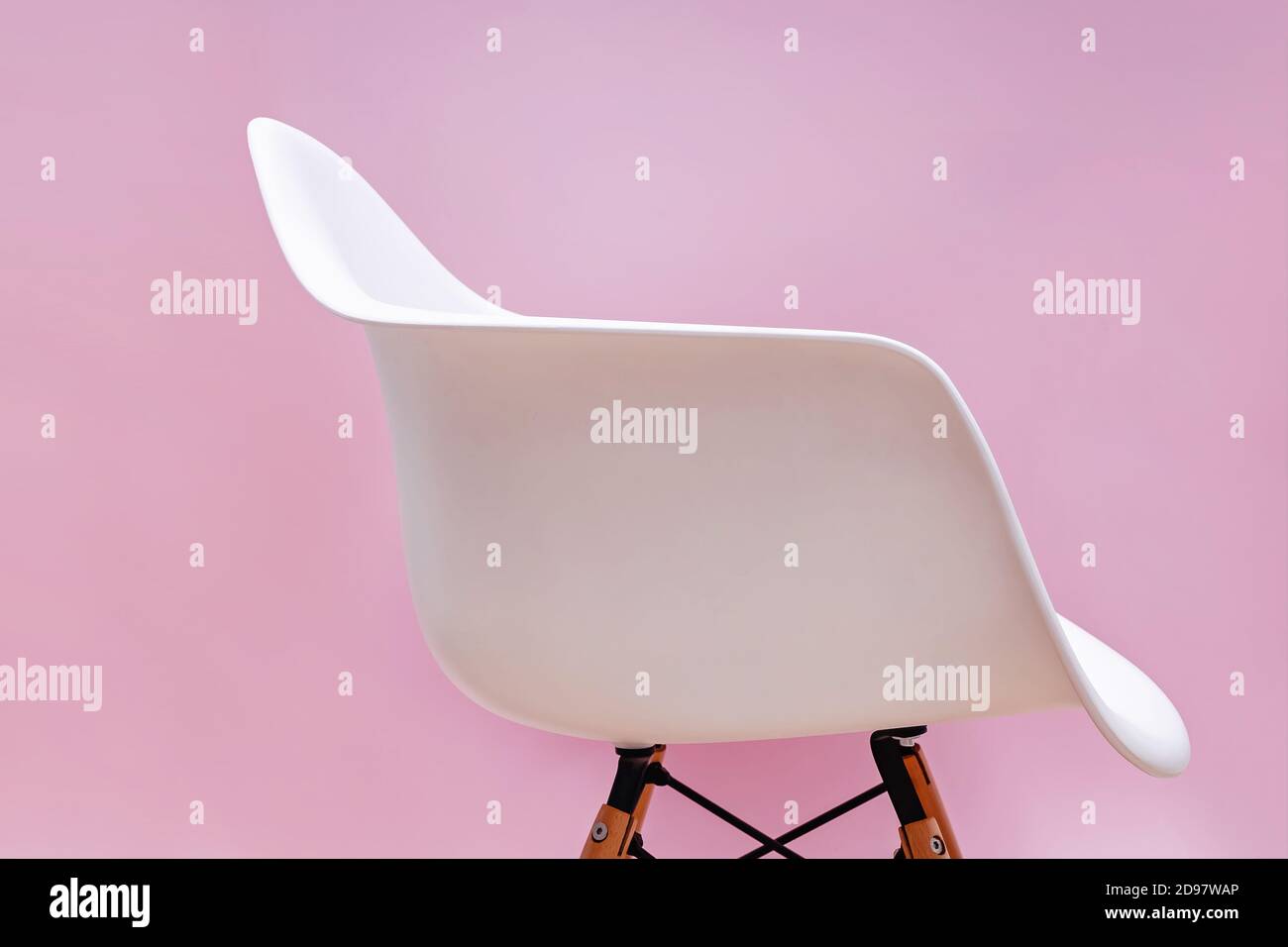 Sedia bianca contemporanea su parete rosa. Foto Stock