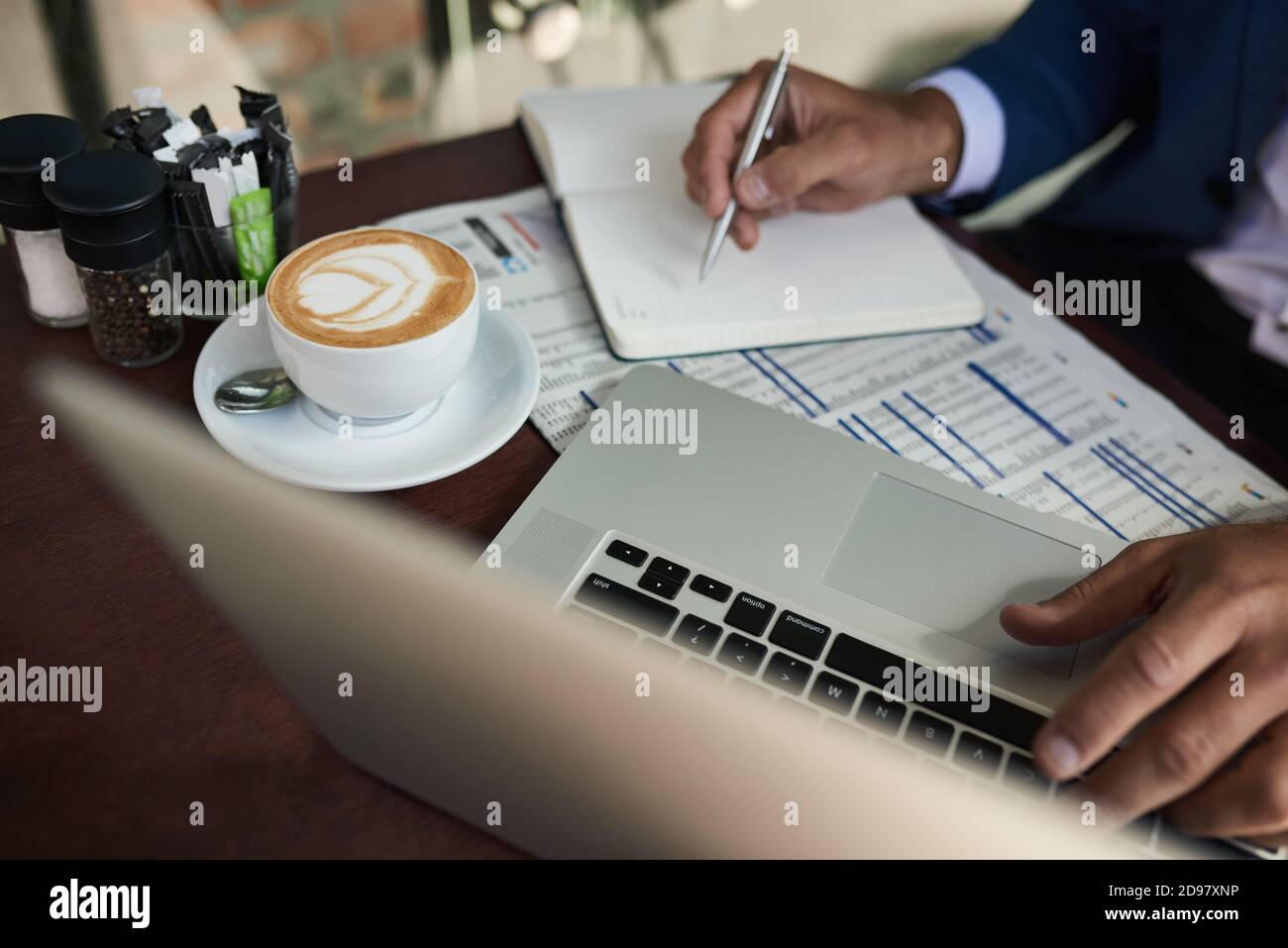 Uomo d'affari che lavora al caffè all'aperto su un tavolo da caffè Foto Stock