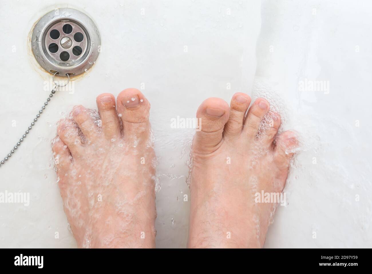 Pelle rugosa sulle dita dei piedi durante la doccia in bagno Foto Stock