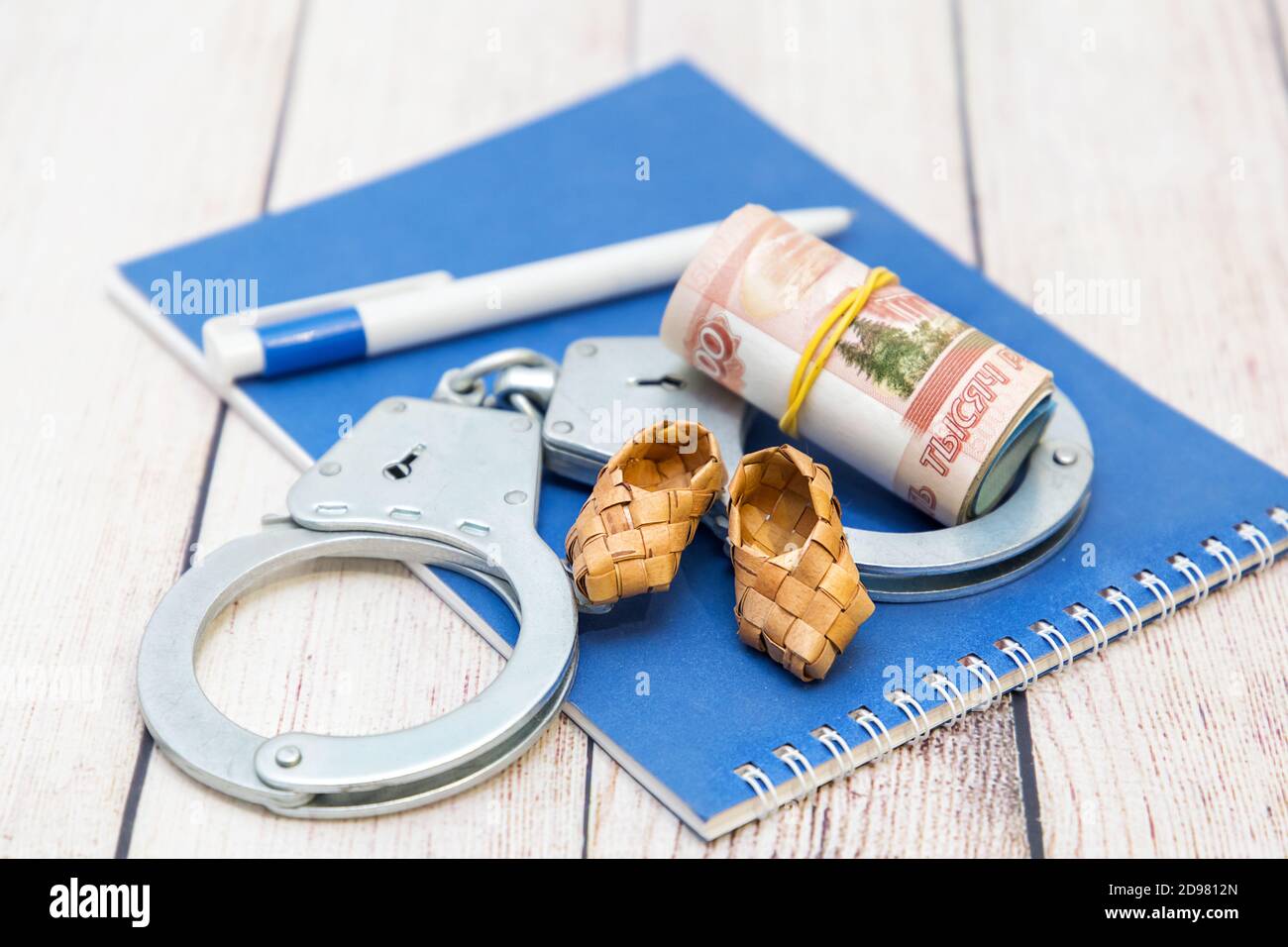 Soldi, manette e scarpe in ghisa. La tentazione del denaro facile Foto Stock